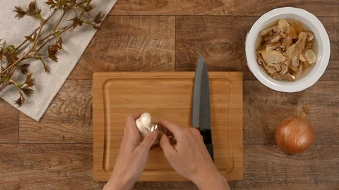Peeling garlic on wooden kitchen table Stock Footage 104014094