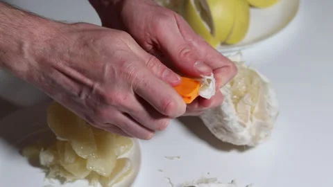 Peeling a grapefruit by hand, removing pith and dividing segments. Stock Footage 326976660