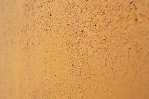 A peeling layer of orange paint on the wall. Stock Photos