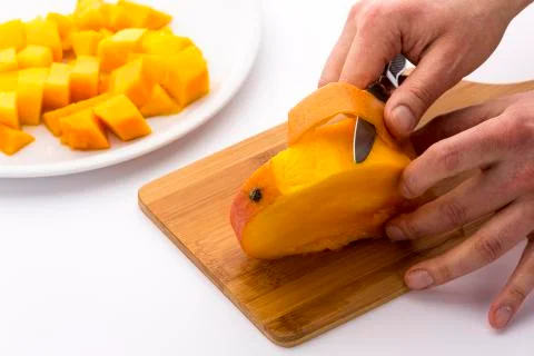 Peeling the mango slice containing the fruit pit Stock Photos