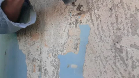 Peeling old paint off the wall with scraper Stock Footage 142329604