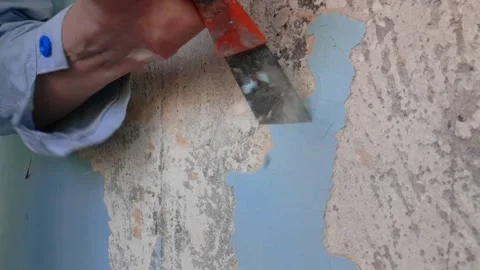 Peeling old paint off the wall with scraper, slow motion Stock Footage 142330100