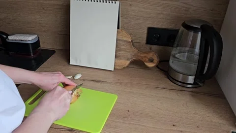 Peeling Onion in Kitchen. Prepping Ingredients. Women's hands peeling onions Stock Footage 305750609