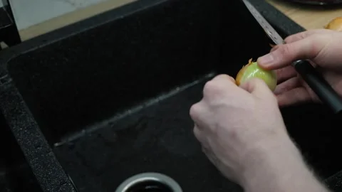 Peeling Onion in the Kitchen Sink Stock Footage 323656422
