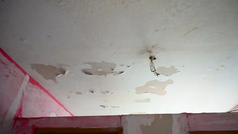 Peeling paint on a ceiling in old house. A neglected room. Stock Footage 261913716