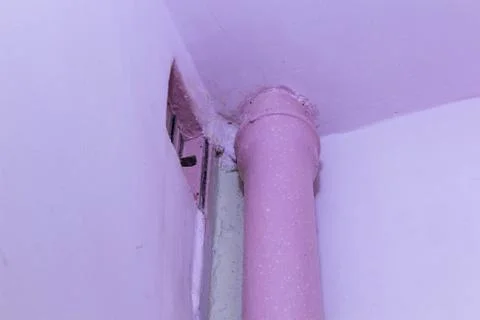 Peeling paint on the ceiling. Rusty water leaking pipe. Repair is required. Фото