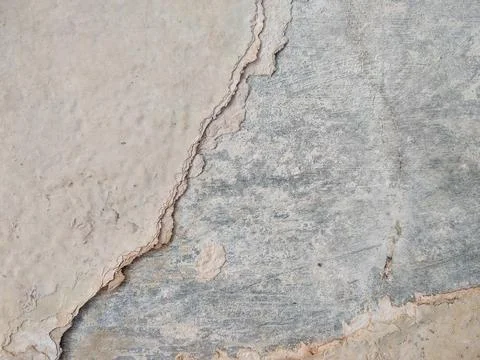 Peeling paint on a wall surface reveals the underlying layer Stock Photos