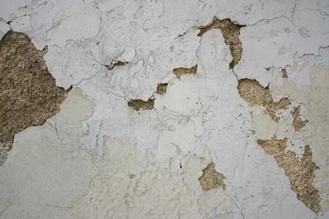 Peeling plaster texture on old concrete wall with weathered stone and crack.. Stock Photos
