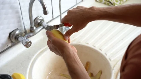 Peeling off potato in the kitchen 2 Stock Footage 117279848