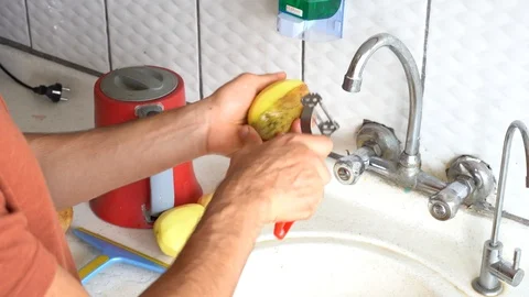 Peeling off potato in the kitchen real time Stock Footage 117279780