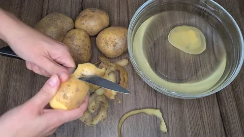 Peeling A Potato. Woman's Hands Peeling Potatoes In The Kitchen  Stock-Footage 165504609