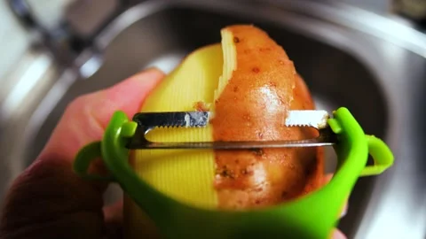 Peeling potatoes close up in the kitchen Video stock 263153304