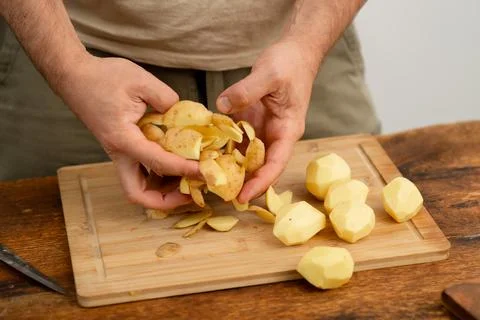 Peeling potatoes for dinner, a simple culinary technique. Stock Photos