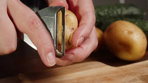 Peeling potatoes with grater close-up. Preparing some vegetables for cooking Stock Footage 260417508