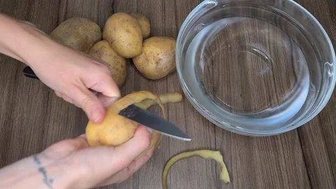 Peeling Potatoes With A Knife. Fresh Vegetables On The Table. Vidéo 165504480