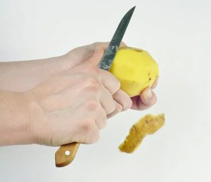 Peeling potatoes with knife Stock Photos