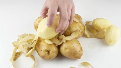Peeling potatoes with a knife.Fresh vegetables on the table. Video stock 136112929