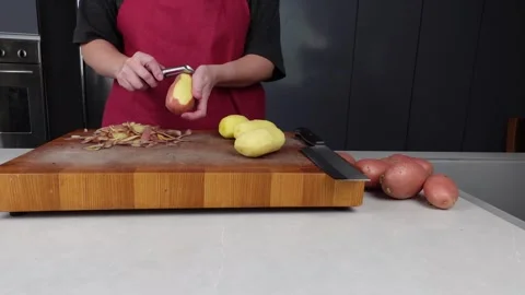 Peeling potatoes in a modern gray kitchen Stock Footage 260232644
