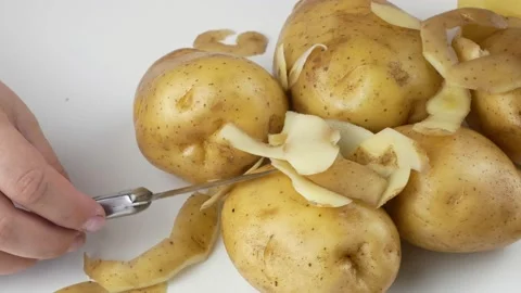 Peeling potatoes a small kitchen knife.Fresh harvest vegetables. Stock-Footage 136303858