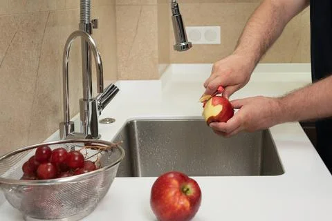 Peeling a red apple close-up in the kitchen Stock Photos