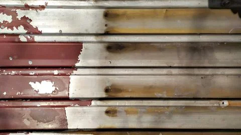 Peeling red paint. dirty profiled metal sheet. Stock Photos