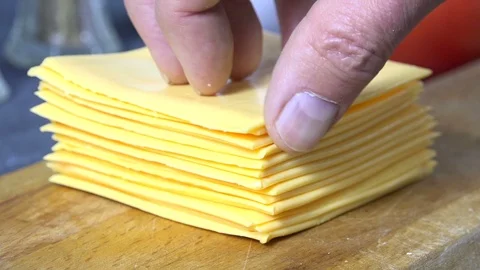 Peeling a slice of cheese off a stack, slow motion Stock Footage 102874923