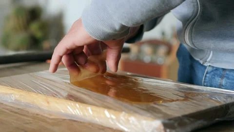 Peeling off the table glue just made. homemade wood glue Stock Footage 154254134