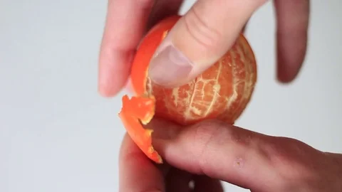 Peeling a tangerine on a white background Stock Footage 71974785