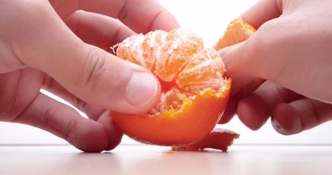 Peeling tangerines on table, 4K video, with sound. Video stock 288787173