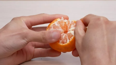Peeling tangerines on table, 4K video, with sound. Stock Footage 295729371