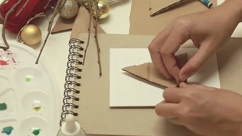 Peeling a triangle cardboard cut out to expose the corrugated side Stock Footage 291160448