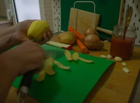 Peeling vegetables in the kitchen Stock Photos