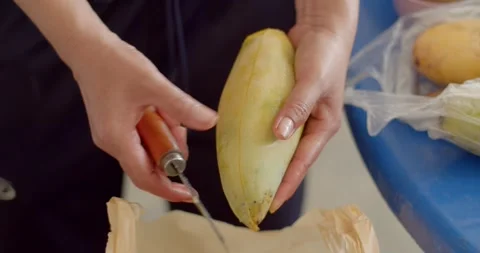 Peeling yellow mango fruit with knife.Appetizing yellow mango.  Stock Footage 240943848