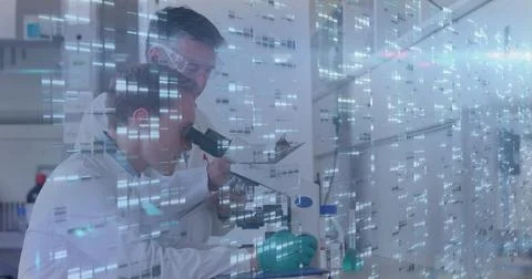Peering scientist examining microscope at lab bench with pipettes code overlay, 스톡 사진