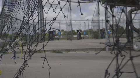 Peering Through Net to Batting Cage Stock Footage 141088765