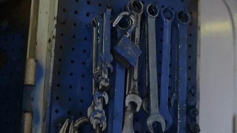 Peg board of hand tools spray painted blue on jobsite wrenches Video stock 125881382