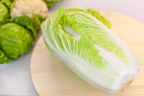 Peking cabbage on the kitchen table, farm vegetables on a light background Stock Photos