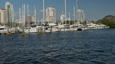 Pelican flys by View from Albert Whitted Playground into south yacht basin in St Stock Footage 289846272