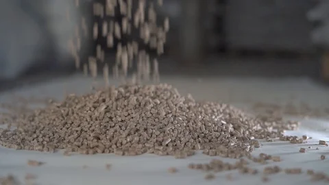 Pellet feed for rural animals falls from a height into a pile. Slow motion Stock Footage 127119686