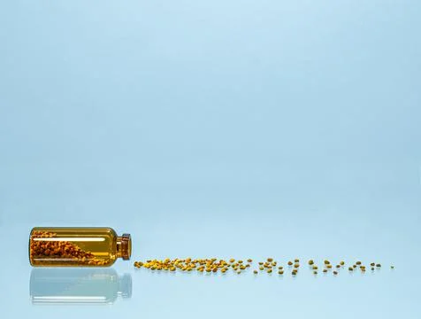 The pellets of bee bread are poured out of the jar. Stock Photos