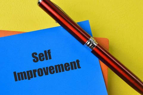 Pen and blue note with text SELF IMPROVEMENT Foto stock