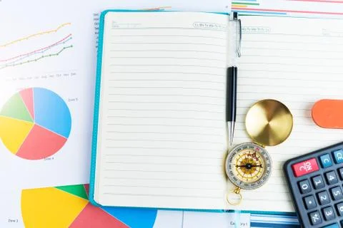 Pen and compass on notebook, graphs, charts, calculator, business table. The Stock Photos