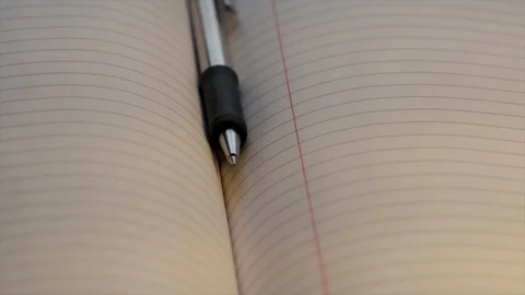 Pen and notebook close up. Open book with empty sheets of lines paper dolly shot Stock Footage 125328621