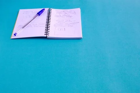 Pen and notebook with notes and drawings on blue background Stock Photos