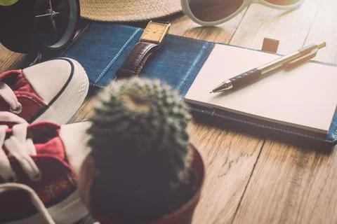 Pen and notebook with personal accessory on table. Stock Photos