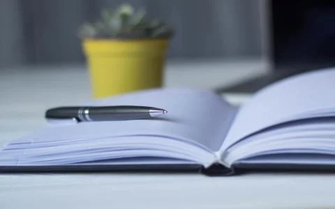 Pen and a notebook at the workplace Stock Photos