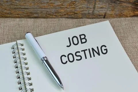 Pen and notebook written with text JOB COSTING Stock Photos