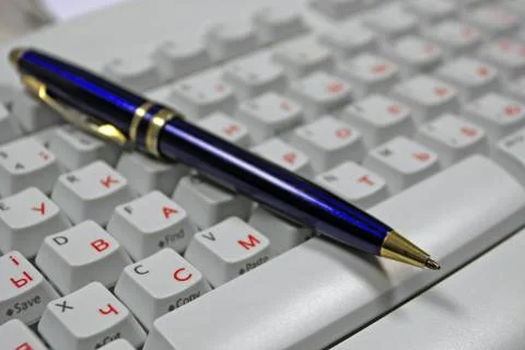 Pen on computer keyboard Stock Photos