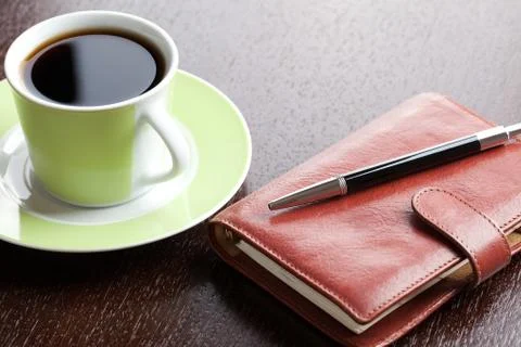 Pen on diary and coffee mug Stock Photos