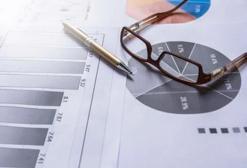 Pen with glasses on document for analyzing financial data and counting. Stock Photos